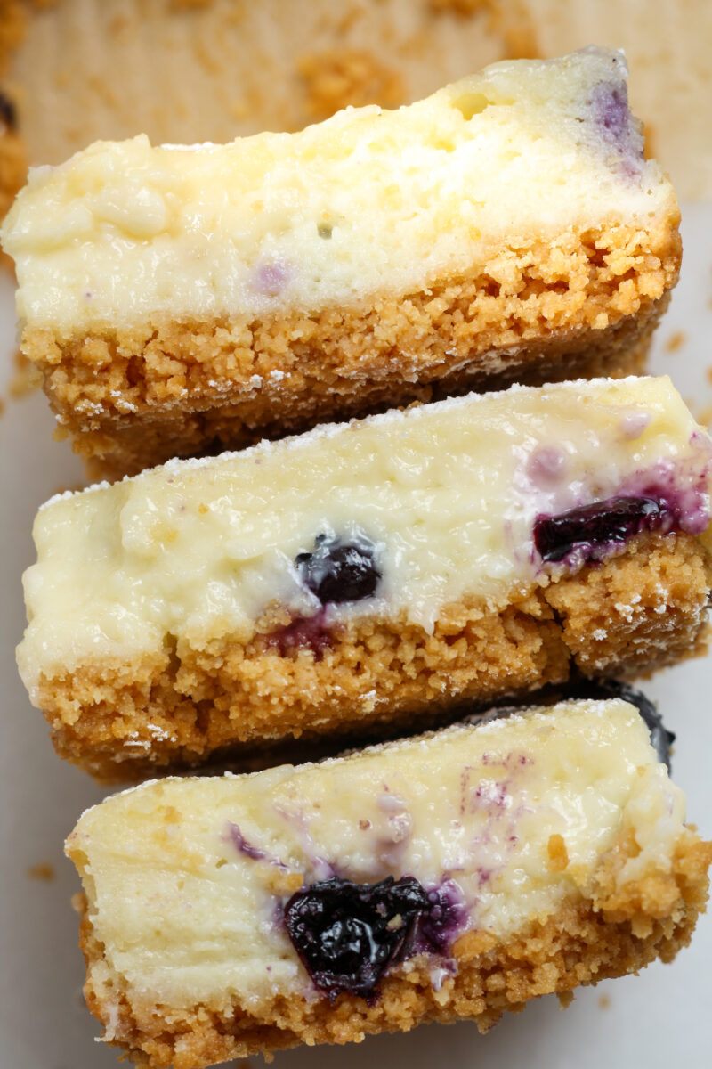 Stack of blueberry cheesecake bars.