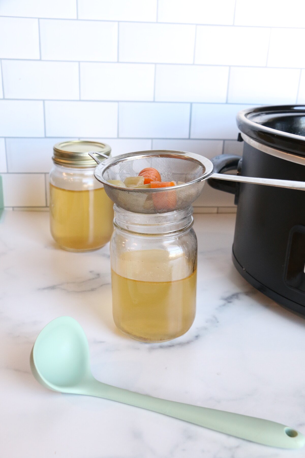 Draining the chicken juice over a sieve to make homemade stock