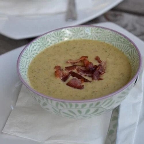 Broccoli cheese soup in a decorative bowl topped with bacon