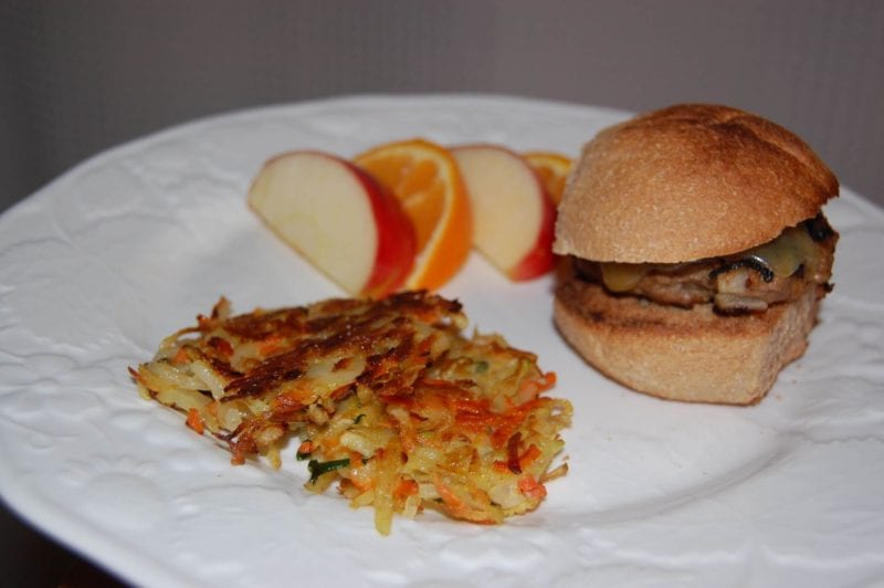 Turkey burgers, veggie pancakes, and fruit on a plate. 