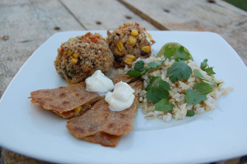 Black bean croquettes, brown rice, and quesadillas on a plate. 
