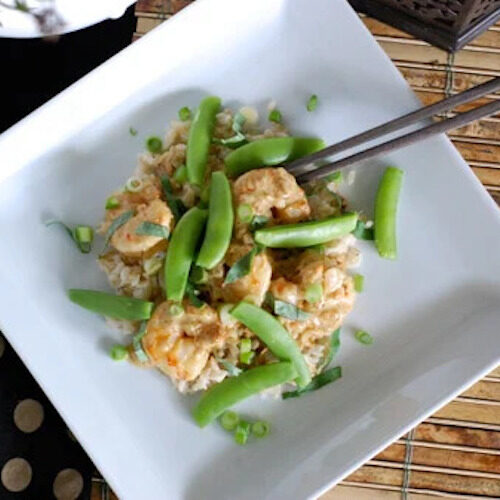 Green Curry Shrimp topped with snap peas on top of brown rice