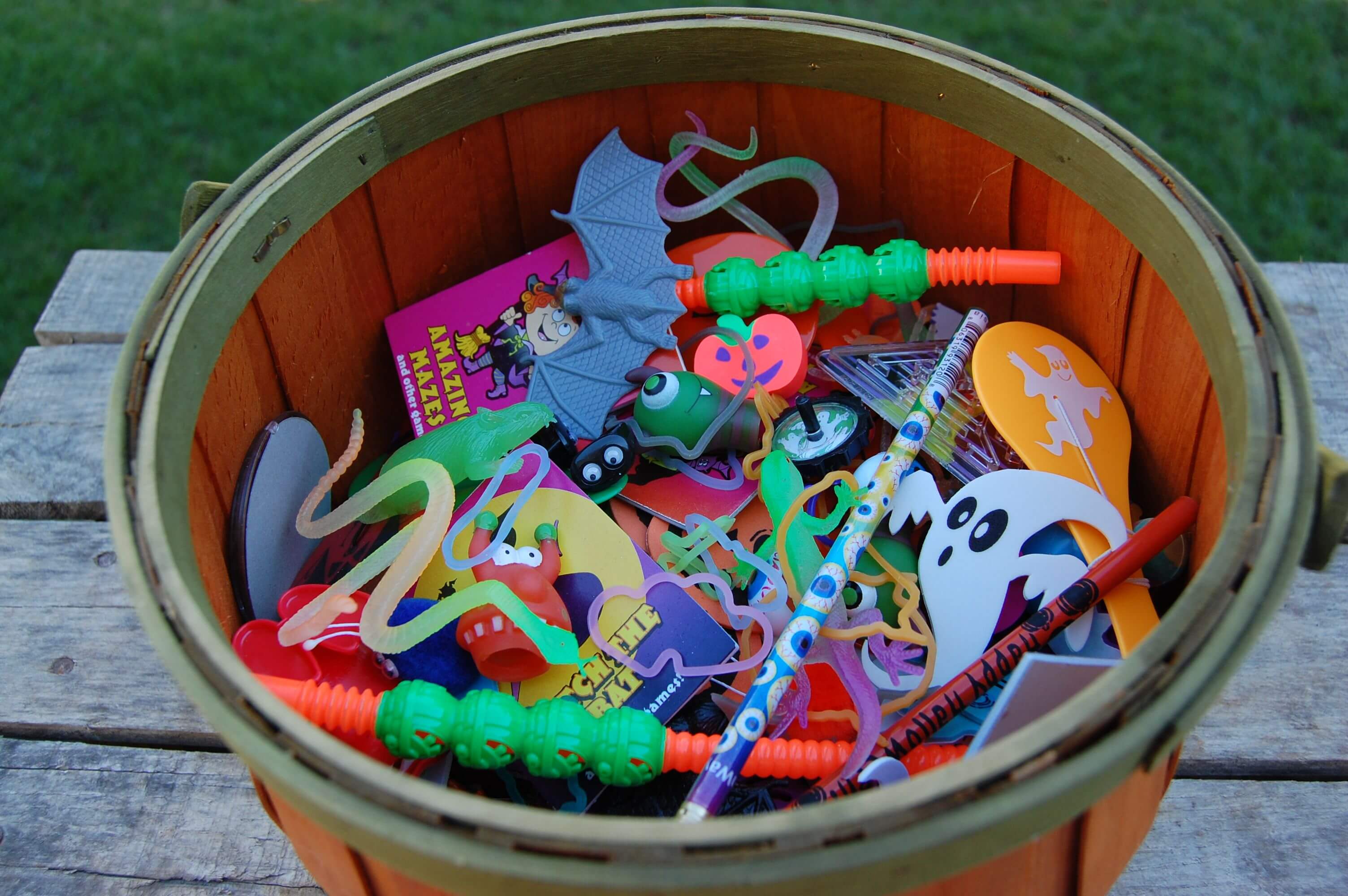 A bin full of small kid toys for halloween. 