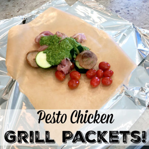 Chicken, tomatoes, mushrooms, zucchini, and pesto sauce on tinfoil