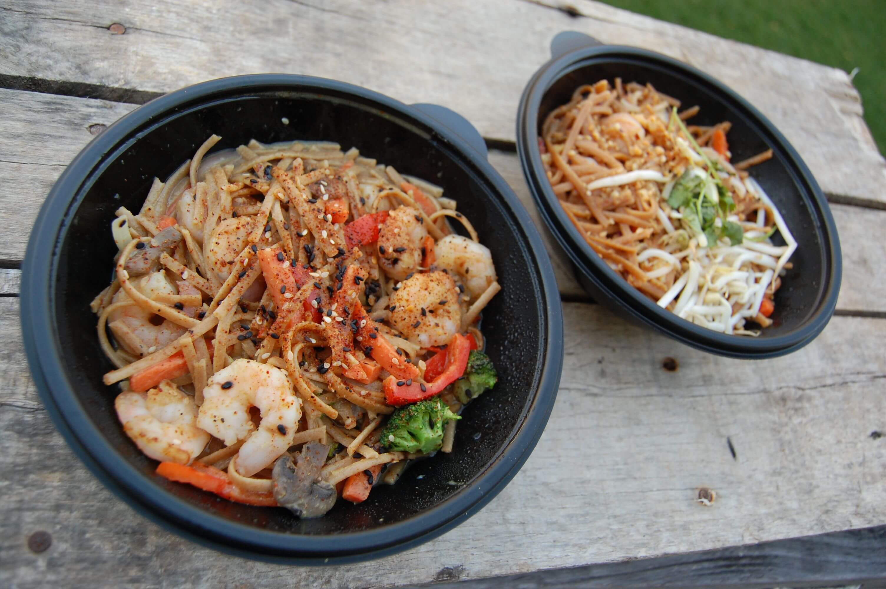 Two bowls of take-out Pad Thai and Curry. 